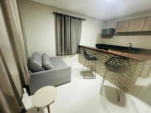 a living room with a couch and a table at Pousada Vila Rose Express Loft in Estivado