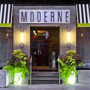 a motel entrance with two plants in front of it at Moderne Hotel in New York