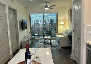 弗赖拉辛Modern & Cozy Apt with pool in prime location的客厅配有沙发和一张桌子及一瓶葡萄酒