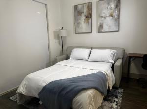 弗赖拉辛Modern & Cozy Apt with pool in prime location的卧室内的一张床铺,墙上有两张照片