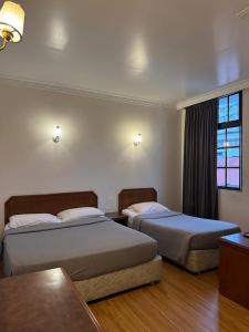 a hotel room with two beds and a window at Hotel Chua Gin @ Brinchang Centre in Brinchang