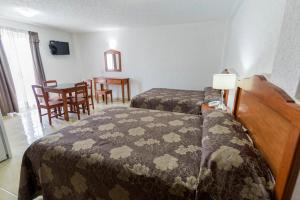Postel nebo postele na pokoji v ubytování Suites Poliforum Inn