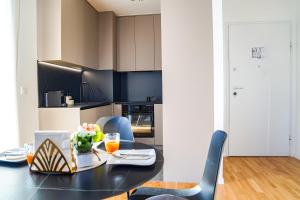 a kitchen with a black table and blue chairs at Apartment Stefani Zadar - Balcony & Free Private Garage Parking in Zadar
