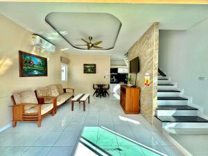 a living room with a staircase and a couch at PrivateRayong in Rayong