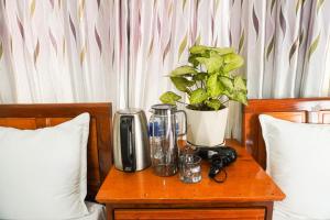 a table with a coffee maker and a plant on a bed at Phong Nha Orient Homestay in Phong Nha