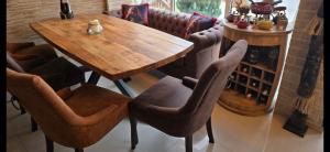 a wooden table and chairs in a room at Апартамент Edelweiss in Beli Iskar