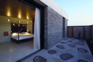 1 dormitorio con cama y pared de ladrillo en Playa Vik Jose Ignacio en José Ignacio