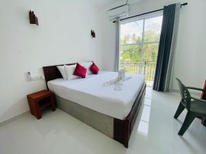 a bedroom with a bed and a large window at Lavish in Weligama