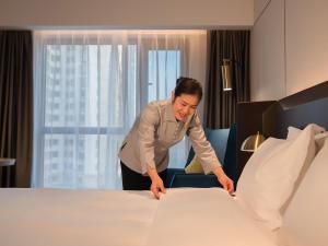 เตียงในห้องที่ Xiangyang Station Minfa World City Yishang Plus Hotel