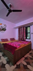 a bedroom with a large bed with a ceiling fan at BlaBla House Rishikesh in Rishīkesh