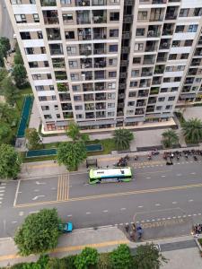 un autobus che passa per una strada di fronte a un grande edificio di Khu đô thị Vinhomes Grand Park Tp Thủ đức Tp HCM a Long Bình