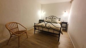 a bedroom with a bed and a chair at La Grange Des Roches Roses in Anchenoncourt-et-Chazel