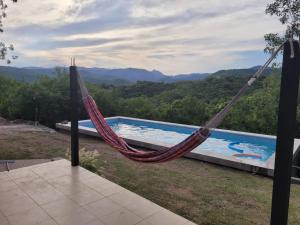 a hammock with a view of a swimming pool at Complejo Los Forasteros Unquillo in Unquillo