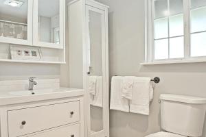 ein weißes Badezimmer mit Toilette und Waschbecken in der Unterkunft Ten Pines Cottage in Ocean Shores + 5 Fotos