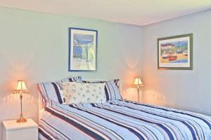 ein Schlafzimmer mit einem Bett mit zwei Lampen in der Unterkunft Ten Pines Cottage in Ocean Shores