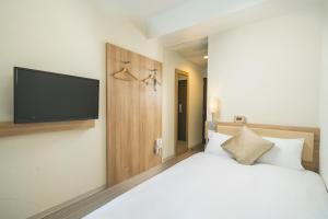 Postel nebo postele na pokoji v ubytování KOKO HOTEL Hiroshima Ekimae