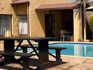 a picnic table next to a swimming pool at La Casa Mia Guesthouse in Kimberley