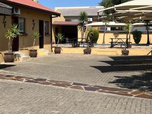 a brick courtyard with potted plants and a building at La Casa Mia Guesthouse in Kimberley