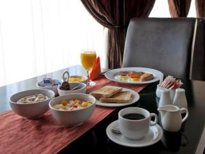 a table with breakfast foods and coffee on it at La Casa Mia Guesthouse in Kimberley