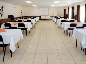a conference room with tables and chairs and a chalkboard at La Casa Mia Guesthouse in Kimberley