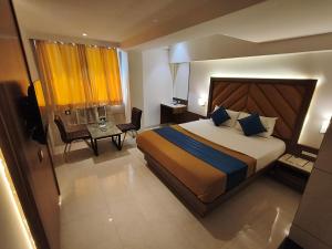 a hotel room with a large bed and a desk at Hotel Nakshtra Residency Kalyan - Premium Couple Friendly in Kalyan