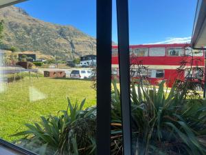 a window with a view of a bus in a yard at Luxury Ludemann Lodge Apartment in Queenstown