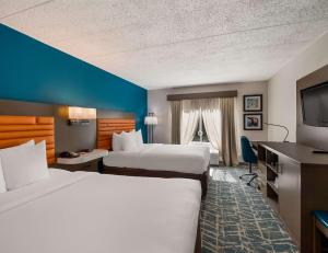 a hotel room with two beds and a flat screen tv at Comfort Inn Falls Church - Tysons Corner in Falls Church