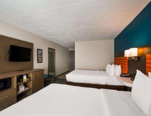 a hotel room with two beds and a flat screen tv at Comfort Inn Falls Church - Tysons Corner in Falls Church