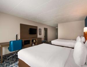 a hotel room with two beds and a tv at Comfort Inn Falls Church - Tysons Corner in Falls Church