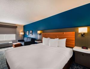 a large bed in a hotel room with a blue wall at Comfort Inn Falls Church - Tysons Corner in Falls Church