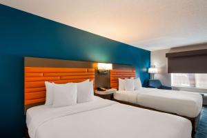 a hotel room with two beds and a blue wall at Comfort Inn Falls Church - Tysons Corner in Falls Church