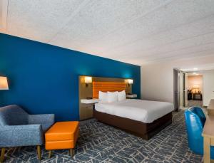 a hotel room with a bed and a blue wall at Comfort Inn Falls Church - Tysons Corner in Falls Church