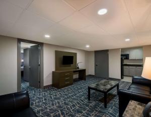 a living room with a couch and a tv at Comfort Inn Falls Church - Tysons Corner in Falls Church