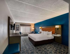 a hotel room with a bed and a blue wall at Comfort Inn Falls Church - Tysons Corner in Falls Church