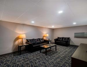 a living room with black leather couches and a table at Comfort Inn Falls Church - Tysons Corner in Falls Church