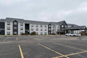 a large white building with cars parked in a parking lot at Country Inn & Suites by Radisson, Elgin, IL in Elgin