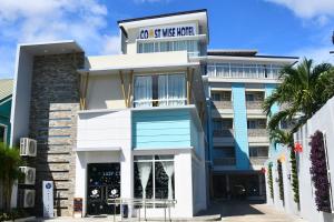 杜马格特Coast Wise Hotel Dumaguete的一座带有在翼楼上读书标志的建筑