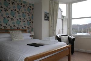 a bed in a room with a window and a bed sidx sidx sidx at The Bay House Lake View Guest House - Adults Only in Bowness-on-Windermere