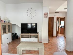 a living room with a flat screen tv and a table at House Lago Azul in Cuevas del Almanzora