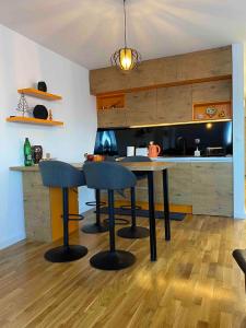 a kitchen with a table and chairs in a kitchen at Apartman 8 Panorama sa garažom in Bjelašnica +11 photos