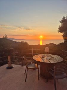a table and chairs on a balcony with a sunset at Dolce&casanova in Farinole