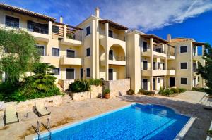 an apartment building with a swimming pool in front of it at Niriides Luxury Apartments in Syvota