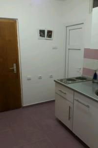 an empty kitchen with a stove and a door at Guest House Oleander in Petrovac na Moru