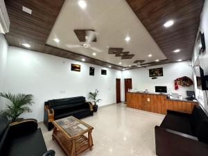 un soggiorno con un divano e un tavolo di Kuyal Corbett Resort a Ramnagar