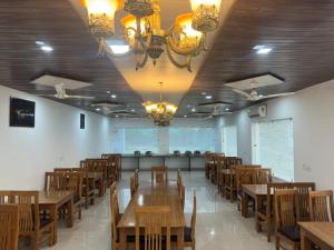 una sala da pranzo con tavoli e sedie in legno di Kuyal Corbett Resort a Ramnagar