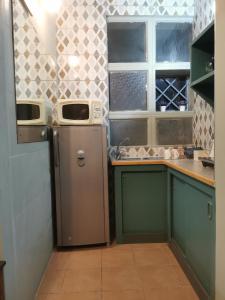 a small kitchen with a refrigerator and a window at Mordillo House in Johannesburg