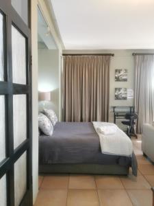 a bedroom with a bed and a desk at Mordillo House in Johannesburg