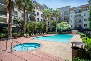 ein Swimmingpool mit Palmen und einem Gebäude in der Unterkunft Union City 2br w gym bbq nr Union Landing SFO-1387 in Union City
