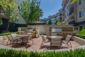 eine Terrasse mit Tischen, Stühlen und einem Grill in der Unterkunft Union City 2br w gym bbq nr Union Landing SFO-1387 in Union City