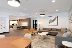 ein Wohnzimmer mit einer Couch sowie Tischen und Stühlen in der Unterkunft Union City 2br w gym bbq nr Union Landing SFO-1387 in Union City